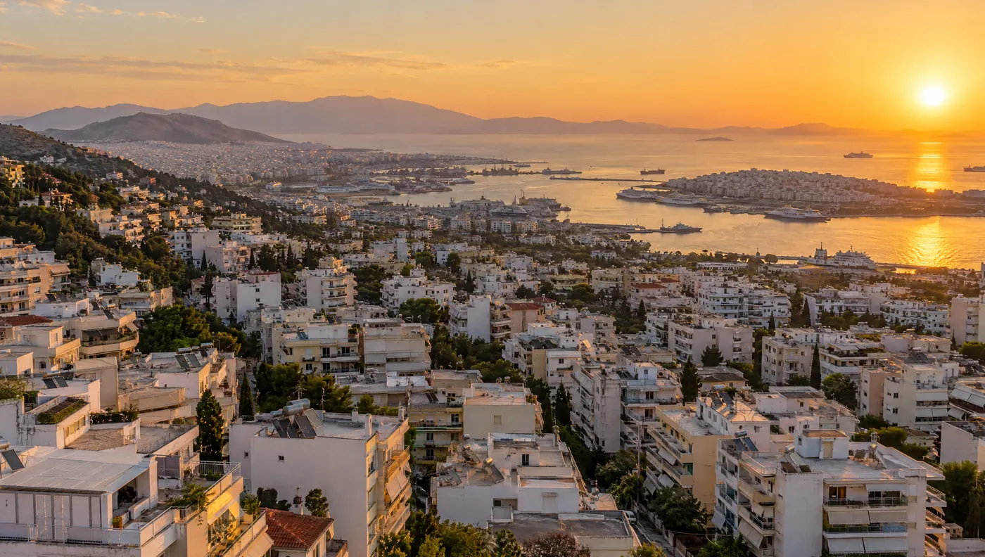 Θέα από ψηλά στα δυτικά προάστια της Αθήνας προς τον Πειραιά στο ηλιοβασίλεμα